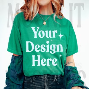 May include: A green t-shirt with the text "Your Design Here" in white. The shirt is being worn by a person with a plaid shirt over it.
