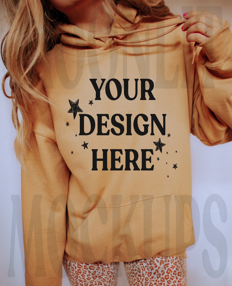 May include: A tan hoodie with a black print that says "YOUR DESIGN HERE" with small stars around the text.