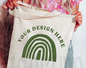 May include: A white canvas tote bag with a green rainbow design and the text "Your Design Here".