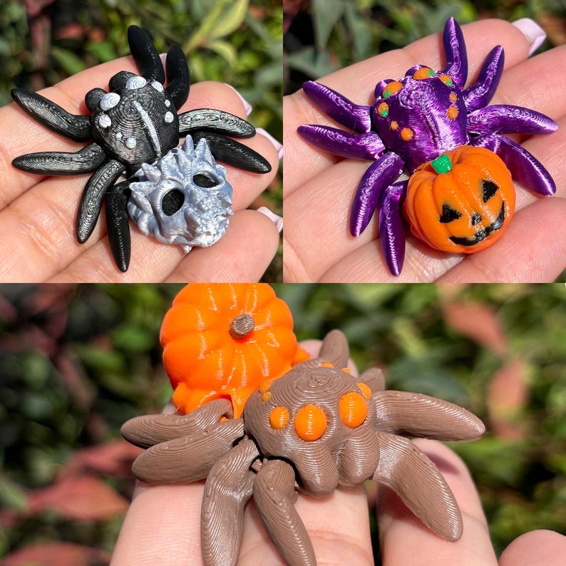 May include: Three 3D printed Halloween spider ornaments. One spider is black with a silver skull, one is purple with a pumpkin, and one is brown with an orange pumpkin.