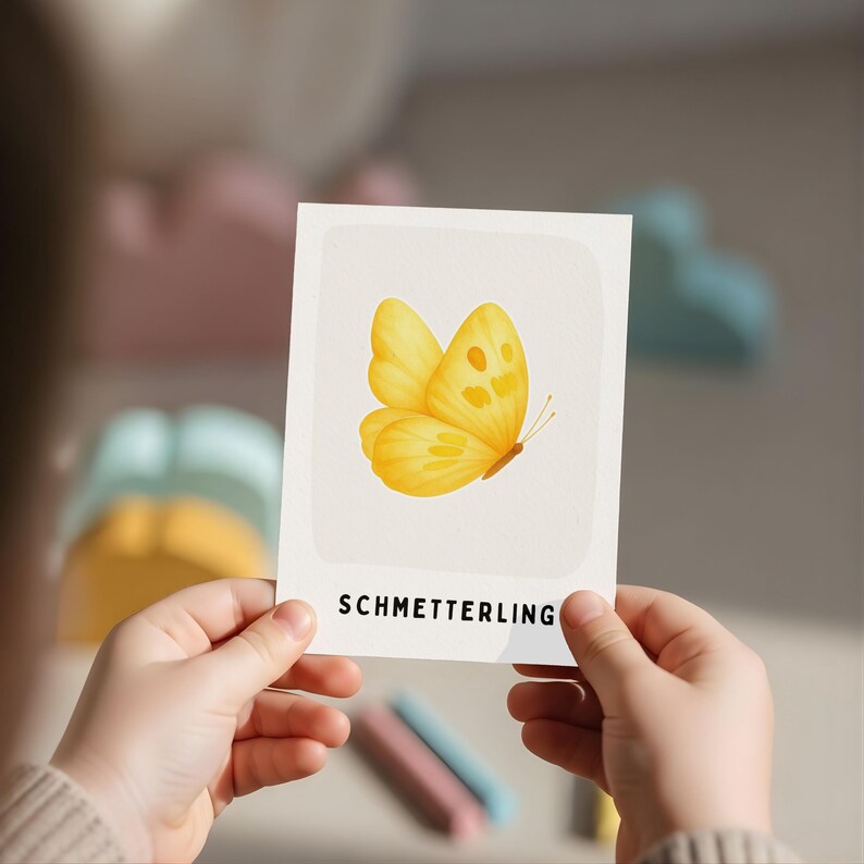 Eine rechteckige weiße Karte mit einer zentralen Illustration eines gelben Schmetterlings mit weichen, abgerundeten Flügeln. Unter dem Schmetterling ist das Wort SCHMETTERLING in fetten, schwarzen, serifenlosen Großbuchstaben aufgedruckt.