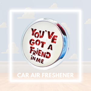 Könnte beinhalten: Ein silberner und roter Auto-Lufterfrischer mit dem Text "You've Got a Friend in Me" in roten Glitzerbuchstaben.