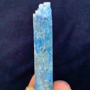 Op de afbeelding: Een lichtblauw aquamarijnkristal met een gestreepte textuur. Het kristal is ongeveer 7,5 cm lang en heeft een licht puntige punt.