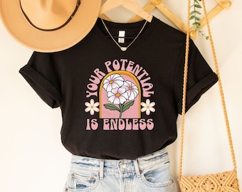 May include: Black t-shirt with a pink and gold graphic of a flower with the text "Your Potential Is Endless".