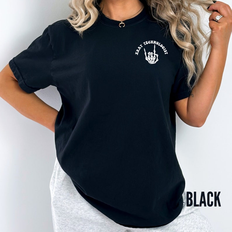 May include: Black t-shirt with a white graphic of a skeleton hand making a rock and roll sign with the text "X-Ray Technologist" around it.