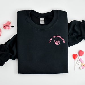 May include: Black sweatshirt with a pink graphic that says "Xray Technologist" with a skeleton hand making a rock and roll sign.