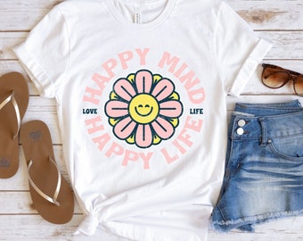 May include: White t-shirt with a pink and yellow flower graphic and the text "Happy Mind Happy Life" with the words "Love" and "Life" on either side of the flower.