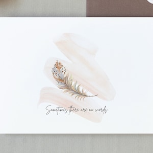 Carte de sympathie décorée d’une seule plume, dans des tons pastel et les mots « parfois il n’y a pas de mots »