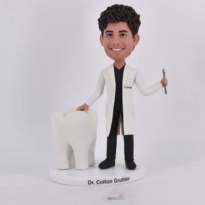 Custom bobbleheads dentist, personalized boblehead for dentist, make a bobblehead for dentist, bobblehead doll standing beside one big tooth