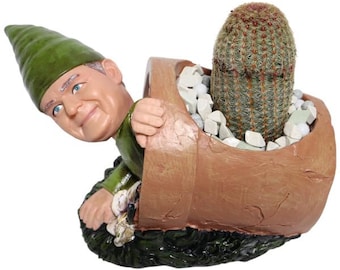 May include: A whimsical garden gnome planter with a smiling face, green hat, and green outfit, holding a brown pot with a cactus and white stones. The cactus is green with red tips.