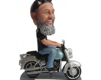 May include: A custom bobblehead figurine of a man with a gray beard wearing a black leather jacket and riding a silver motorcycle. The base of the figurine has the text "Pappy and Josefine".