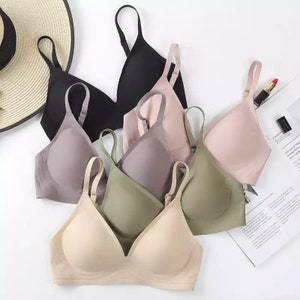 May include: Five seamless bras in different colors, including black, gray, beige, green, and pink. The bras are made of a soft, stretchy fabric and have adjustable straps.