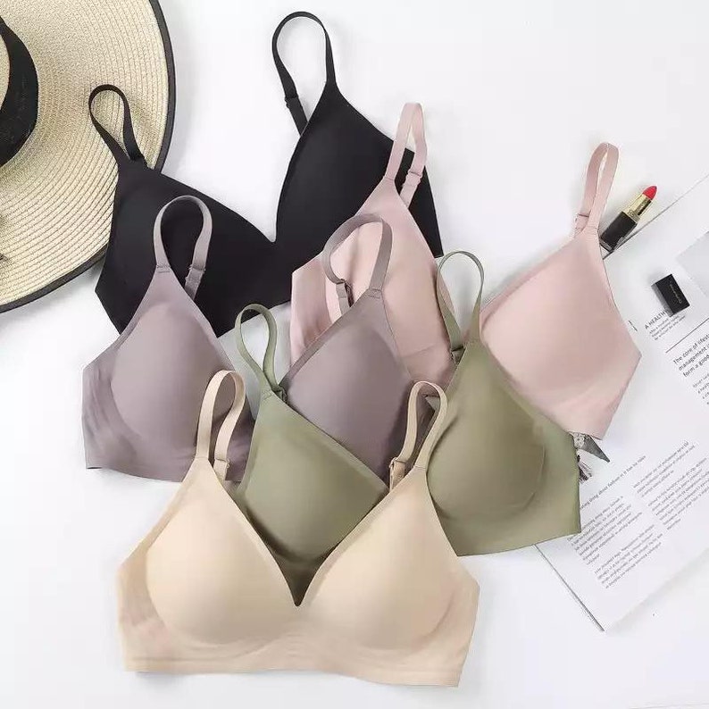 May include: Five seamless bras in different colors, including black, gray, beige, green, and pink. The bras are made of a soft, stretchy fabric and have adjustable straps.