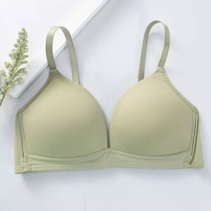 May include: A light green seamless bra with adjustable straps. The bra has a smooth, comfortable fabric and a v-neckline.