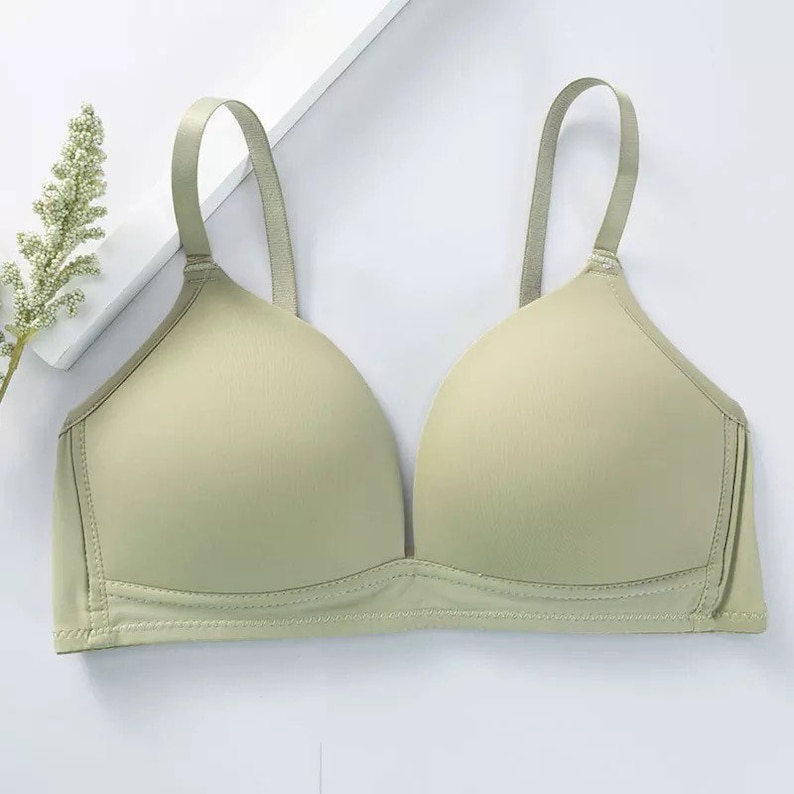May include: A light green seamless bra with adjustable straps. The bra has a smooth, comfortable fabric and a v-neckline.