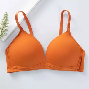 May include: A bright orange seamless bra with adjustable straps.