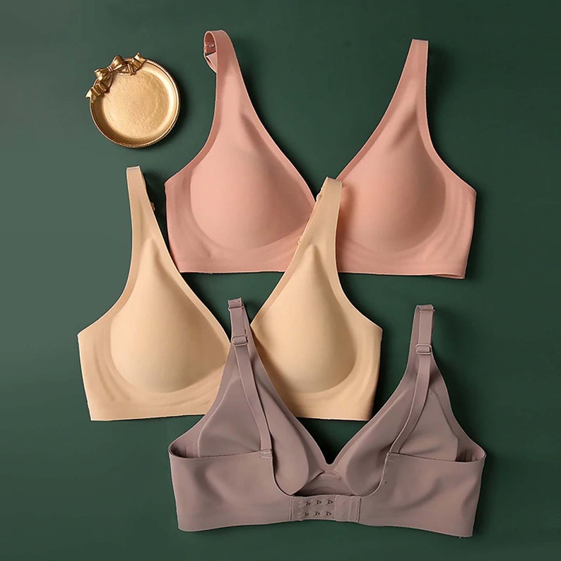 May include: Three seamless bras in different colors: pink, beige, and gray. The bras have adjustable straps and a smooth, comfortable fit.