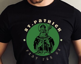 May include: Black t-shirt with a green circle graphic featuring a drawing of Saint Patrick holding a staff. The text "St. Patrick Pray For Us" is written around the circle.