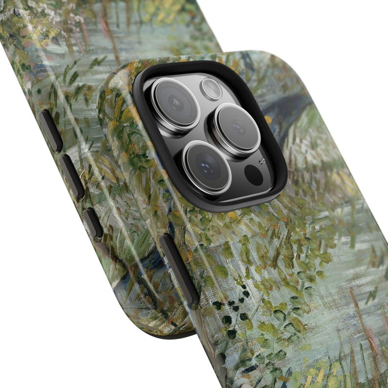 Peut inclure: Une coque de t&eacute;l&eacute;phone avec un motif de peinture impressionniste vert et jaune. L'&eacute;tui a un bord noir pour l'objectif de la cam&eacute;ra et des boutons lat&eacute;raux noirs. L'&oelig;uvre repr&eacute;sente un paysage avec de l'eau et du feuillage.