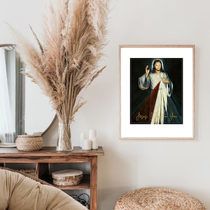 Puede incluir: Una impresión enmarcada de una pintura que representa a Jesucristo con su corazón expuesto, rodeado de rayos de luz. El texto "Jesús, confío en ti" está escrito en letras doradas en la parte inferior de la impresión.