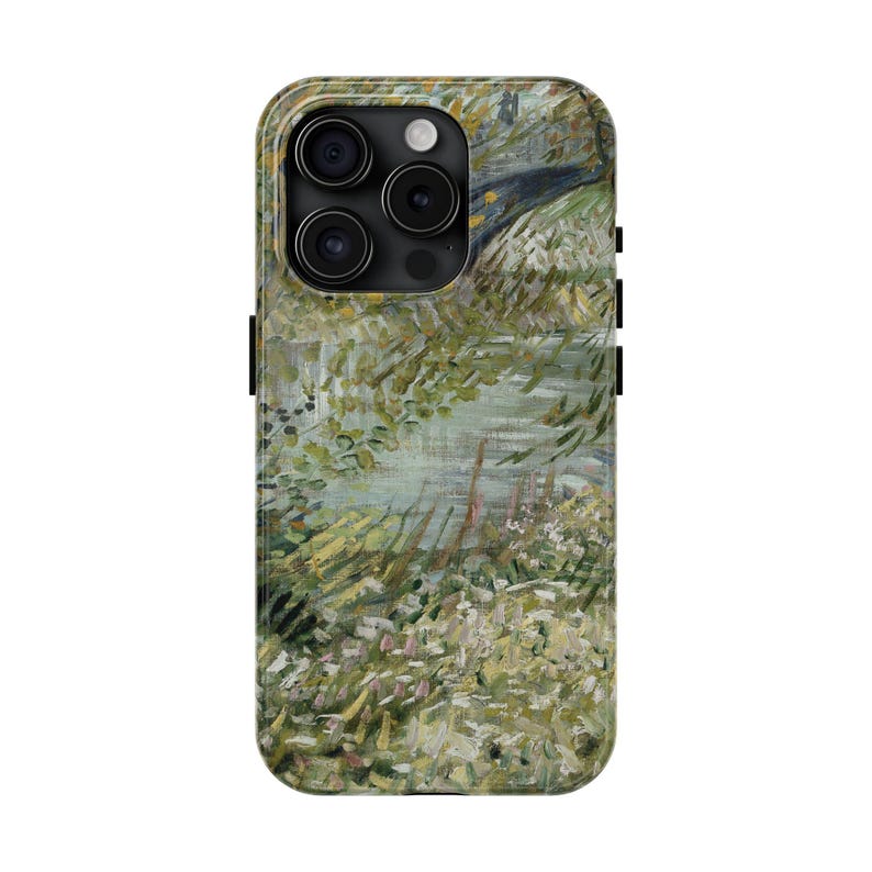 Peut inclure: Une coque de t&eacute;l&eacute;phone avec une peinture de paysage dans les tons de vert, jaune et bleu. L'&oelig;uvre repr&eacute;sente une sc&egrave;ne naturelle avec des arbres, de l'eau et du feuillage. L'&eacute;tui a un bord noir et des d&eacute;coupes pour l'objectif de la cam&eacute;ra.