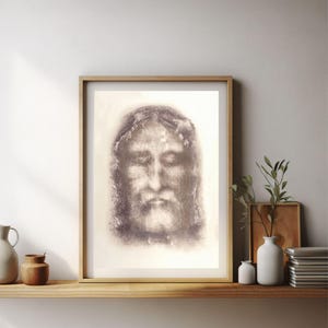 Puede incluir: Un dibujo en blanco y negro de la cara de un hombre con los ojos cerrados. El dibujo está sobre un fondo blanco y está enmarcado en un marco de madera claro.