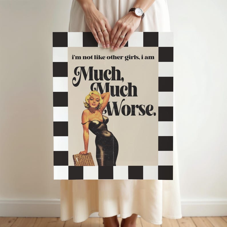 May include: A framed print featuring a vintage-style image of a woman in a black dress, with the text "Much, Much Worse." The frame has a black and white checkered pattern. The woman is blonde and leaning on a basket.