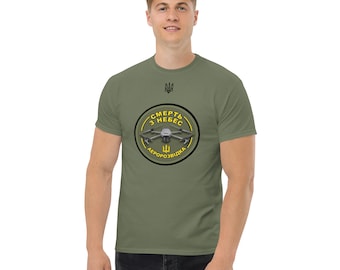 May include: A green t-shirt with a yellow circle graphic featuring a drone and the text "СМЕРТЬ З НЕБЕС АЕРОРОЗВІДКА" in black.