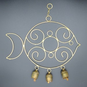 Peut inclure: Carillon en métal doré en forme de poisson avec une queue de croissant de lune. Le poisson a un design circulaire avec cinq volutes et quatre cloches suspendues.