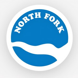 May include: A white ceramic mug with a black handle and the text "But First, Coffee" in a bold, black font. The mug is set against a blurred background, suggesting a cozy setting.