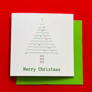 Könnte beinhalten: Eine weiße Weihnachtskarte mit einem grünen Umschlag. Die Karte zeigt ein Weihnachtsbaumdesign aus Symbolen und die Worte "Merry Christmas" in Grün. Der Hintergrund ist rot.