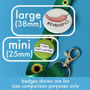 May include: A green lanyard with sunflower patterns and a silver clasp. Two button badges are shown for size comparison: a large 38mm badge with a chili pepper and the text "NEUROSPICY", and a mini 25mm badge with the text "I am non-verbal".