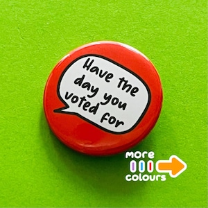 May include: A circular red badge with the phrase "Have the day you voted for" in a white speech bubble. The badge also features the words "more colours" and an arrow.