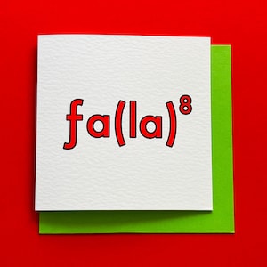 May include: A white greeting card with the text "fa(la)⁸" in red, set against a green backing and a red background. The card has a textured surface.