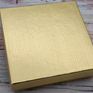 May include: A gold gift box with a textured surface.