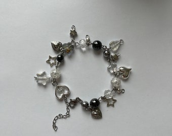 May include: A silver charm bracelet with black and clear beads, silver stars, and heart charms.