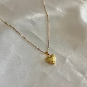 Peut inclure: Un collier avec un pendentif en forme de cœur en or et une chaîne délicate.