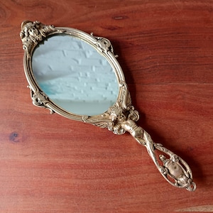 MIRROR decorated with bronze cherubs, hand-held brass vanity mirror