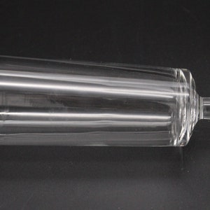 Puede incluir: Una flauta de champ&aacute;n de vidrio transparente con una base ancha. La flauta est&aacute; tumbada de lado.