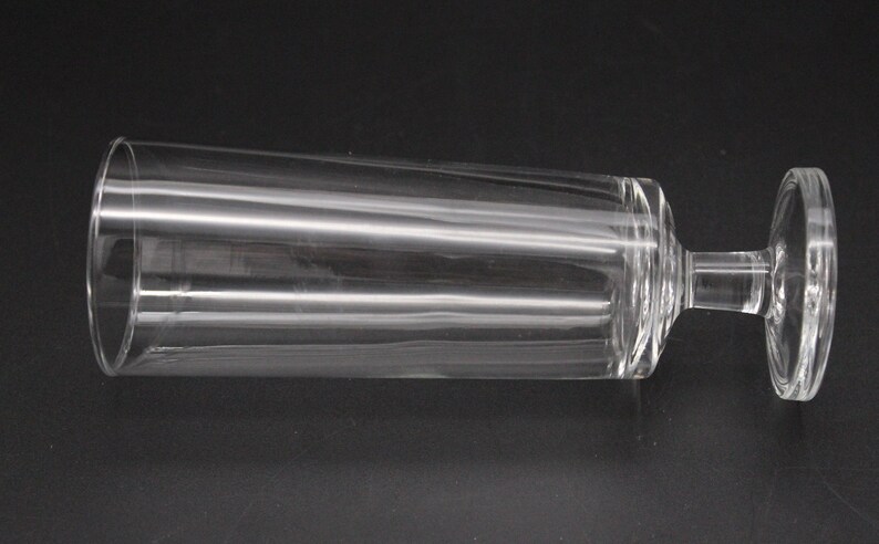 Puede incluir: Una flauta de champ&aacute;n de vidrio transparente con una base ancha. La flauta est&aacute; tumbada de lado.