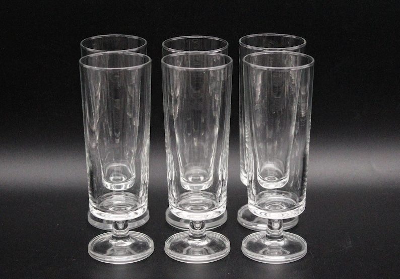 Puede incluir: Juego de seis vasos de beber de vidrio transparente con forma alta y cil&iacute;ndrica y base corta y acampanada.