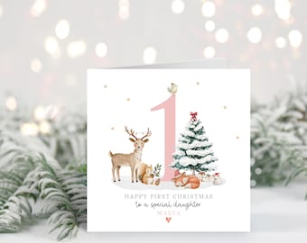 May include: A Christmas card with a watercolor illustration. The card features a pink number 1, a Christmas tree, a deer, a fox, and a squirrel. The text reads "Happy First Christmas to a special daughter".