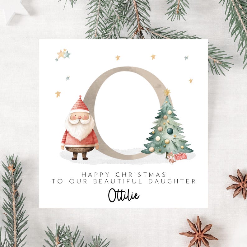 May include: A Christmas card with a watercolor illustration. It features a Santa Claus figure, a decorated Christmas tree, and the text "Happy Christmas to our beautiful daughter Ottilie."