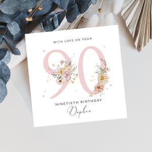 May include: A pink floral birthday card with the number 90 decorated with flowers. The card says "With love on your ninetieth birthday Daphne".