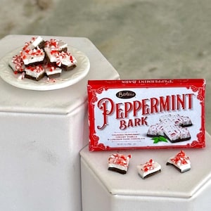 May include: A box of Barton's Peppermint Bark candy with a red background and white lettering. The box shows a close-up of the peppermint bark with white chocolate and crushed peppermint.