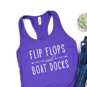 May include: Purple tank top with the text "Flip Flops and Boat Docks" in white. The text is surrounded by arrows and hearts.
