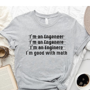 May include: A gray t-shirt with the text "I'm an Engeneer" repeated three times with a line through each word. The text "I'm good with math" is below the repeated text.