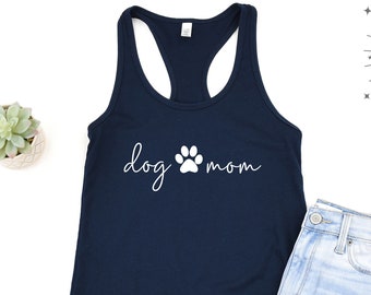 May include: A navy blue racerback tank top with the text "dog mom" in white cursive lettering and a white paw print between the words.
