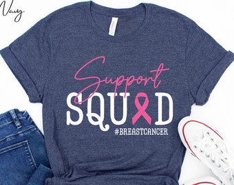 May include: A navy blue t-shirt with the text "Support Squad" in white with a pink ribbon and the hashtag "#BreastCancer" in pink.