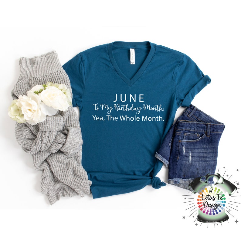 Puede incluir: Camiseta azul turquesa de cuello en V con el texto "JUNE Is My Birthday Month: Yea, The Whole Month." en letras blancas. La camiseta est&aacute; colocada sobre una superficie blanca con un su&eacute;ter gris y unos pantalones cortos de mezclilla azul.
